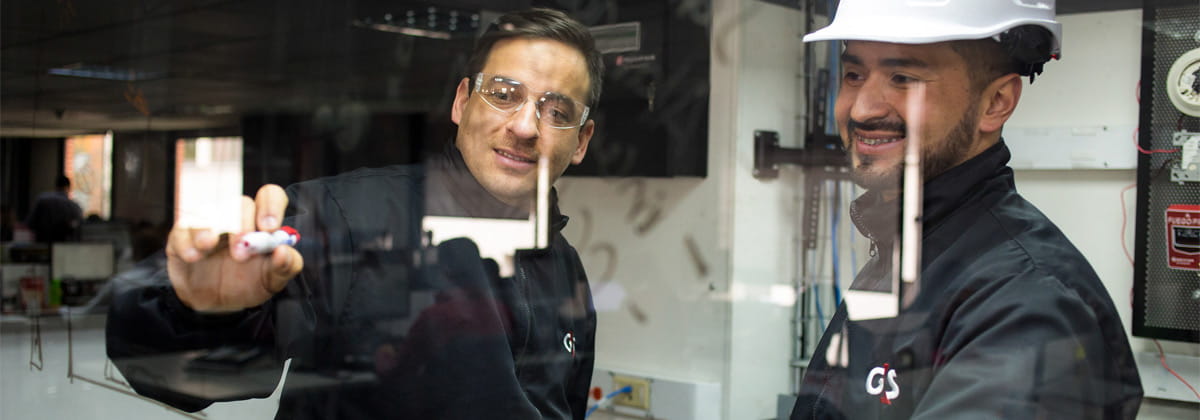 Two security professionals discussing a topic and writing on a board