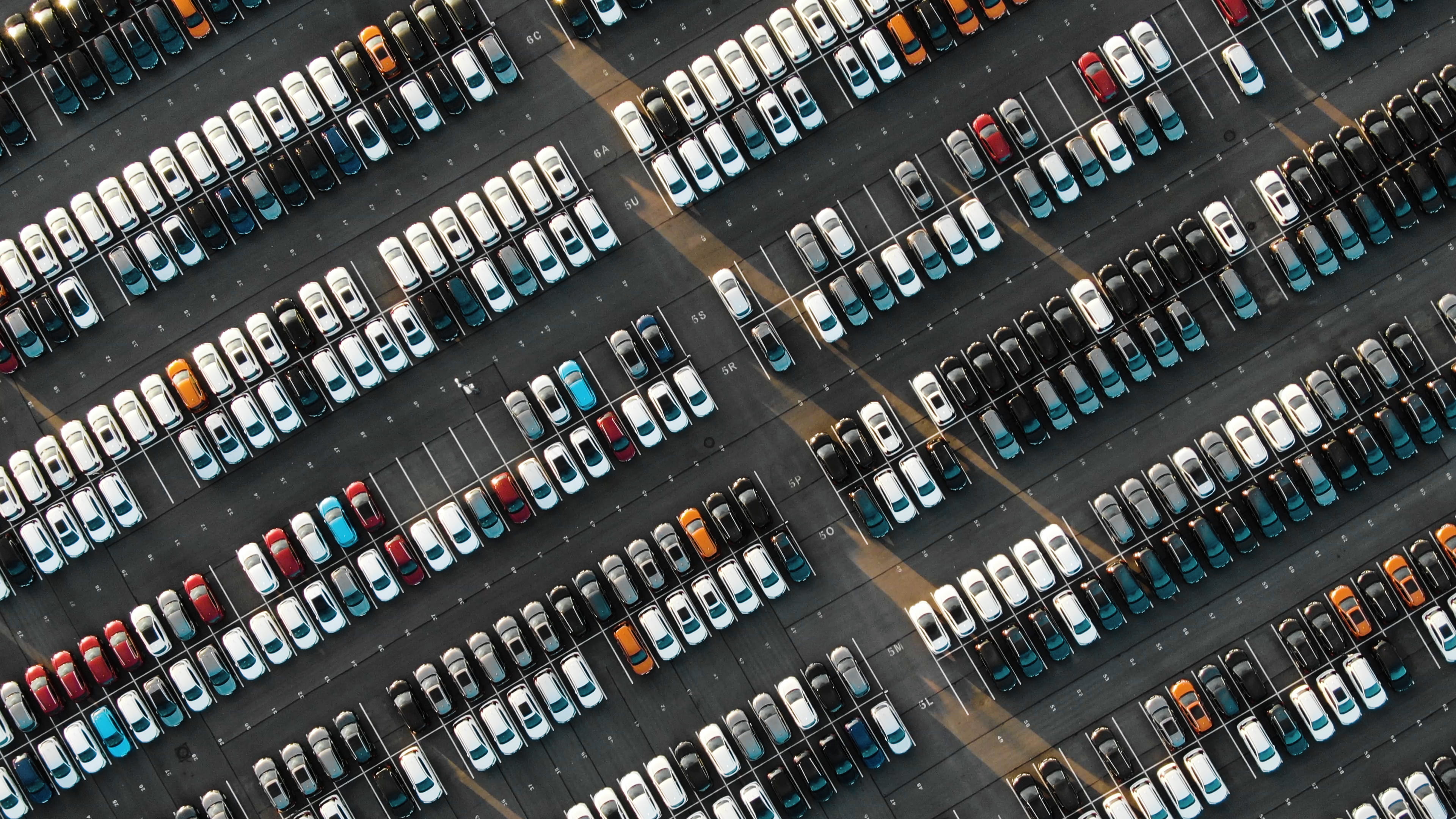 A parking lot full of vehicles parked neatly