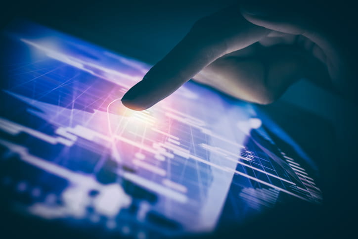 A finger tapping at a screen with white lines in a graph