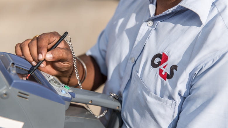 G4S Security Guard inputting information into a digital console