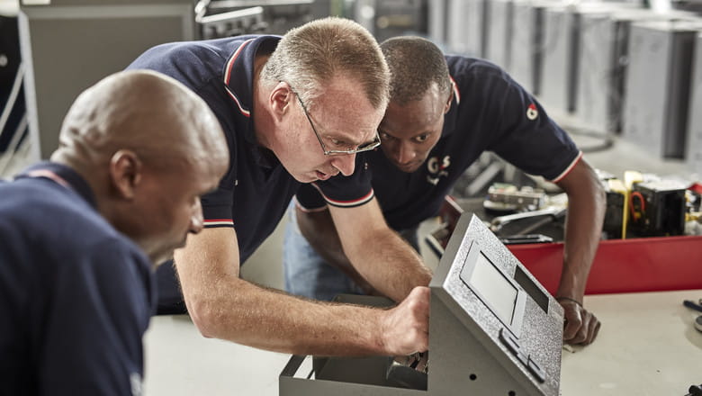 Three people fixing a device
