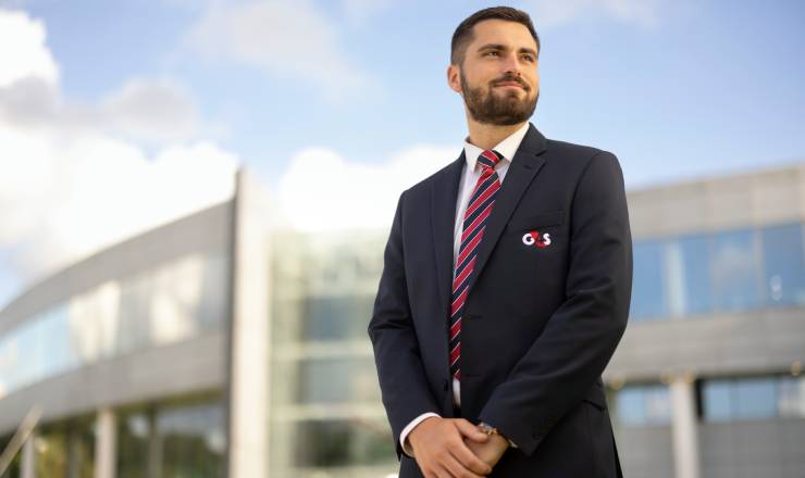 A G4S security professional in branded uniform looking off camera to the right hand-side