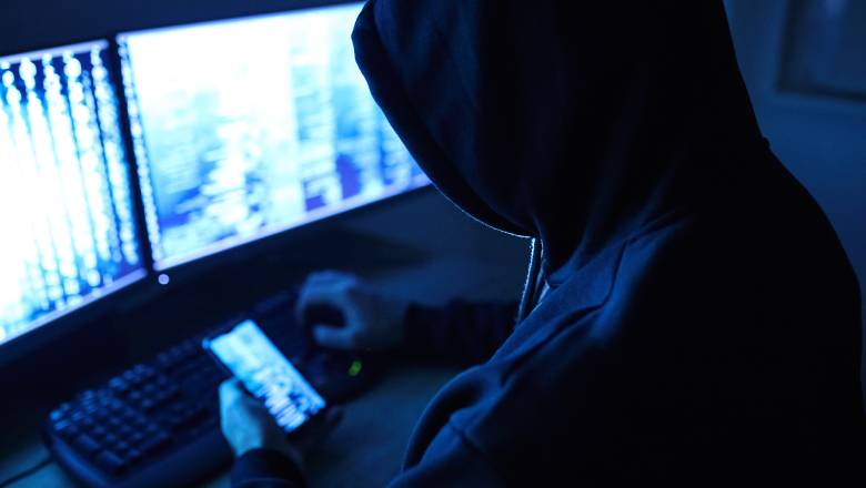 An insider retrieving confidential data on their phone and computer screen