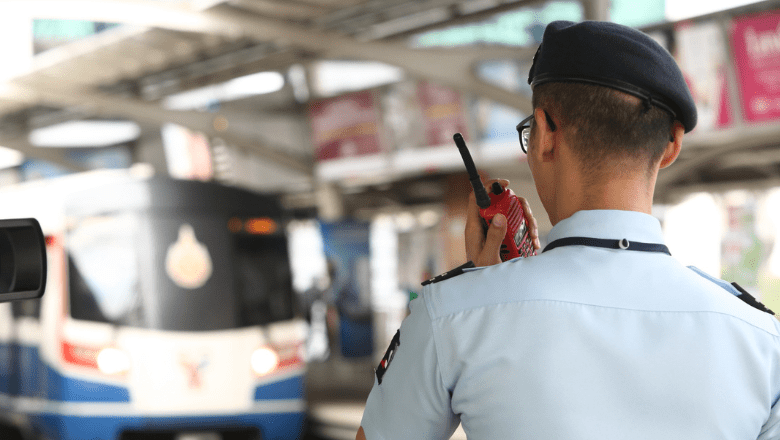A male security guard on duty on a metro platform