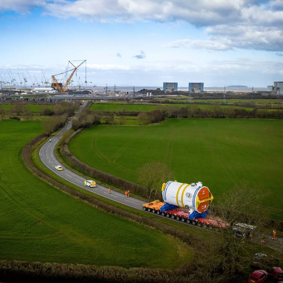 An aerial photograph of security officers escorting a generator towards the Hinkley Point C construction site