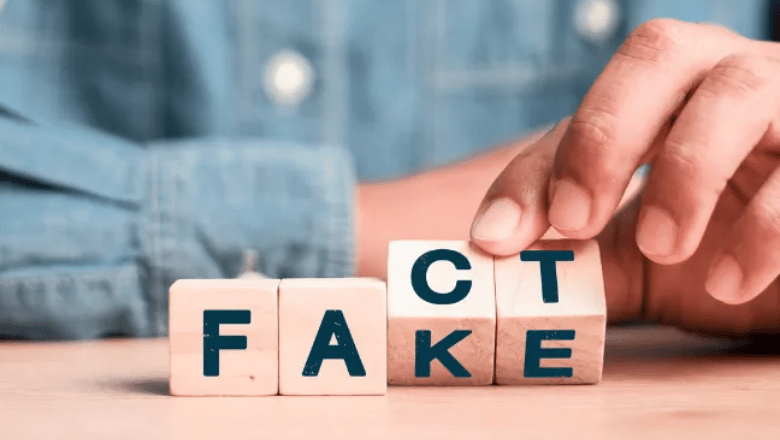 Wooden cubes with letters of fact and fake on a desk