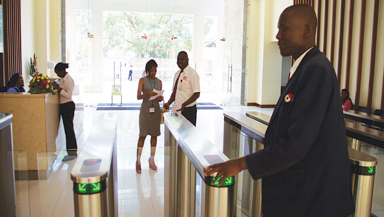 A security checkpoint in a building lobby with three people visible