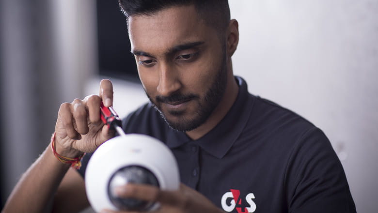 A G4S employee inspecting a CCTV device