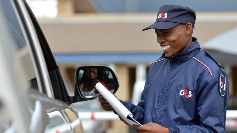 Security guard checking a vehicle entering to a parking lot
