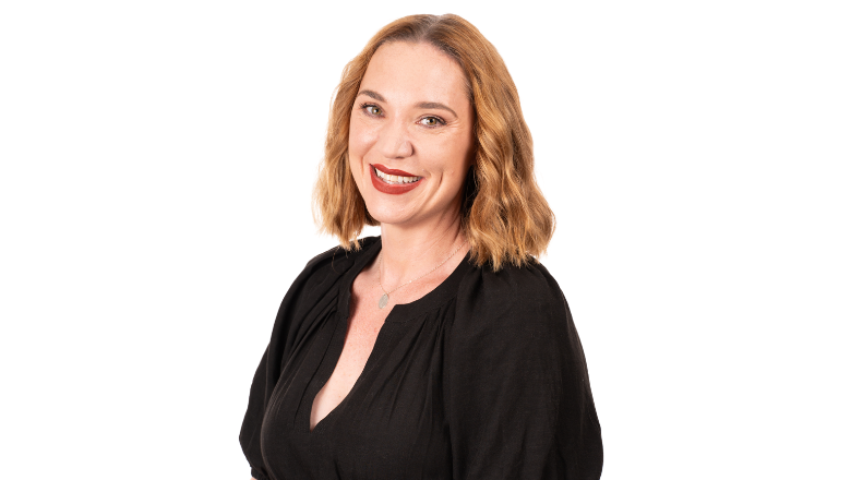 A corporate woman with red lipstick and a black dress smiling at the camera