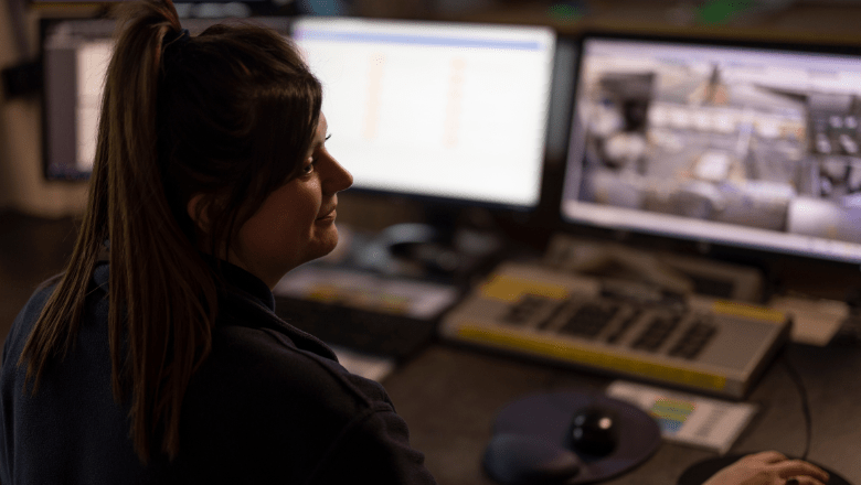 A female sitting in front of computer screens