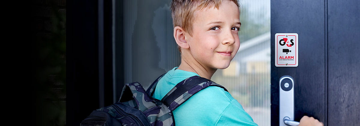 Dreng åbner dør med et alarmskilt