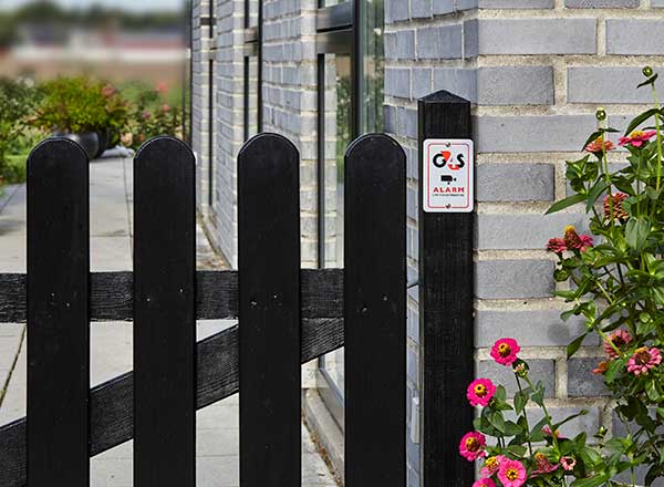G4S alarmskilt på et hegn i en have