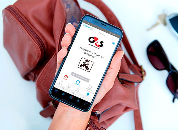Kvindes viser en app hvor man kan se, at G4S alarmen har afsløret røg i stuen