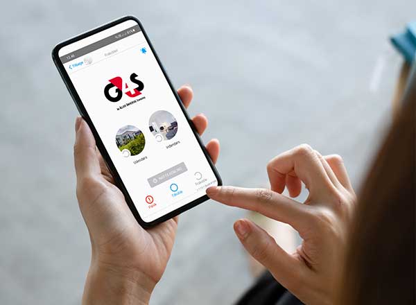 Kvinde ser på G4S app på sin mobiltelefon