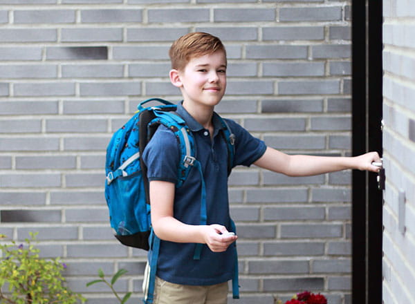 Dreng slår alarmen fra og smiler til kameraet