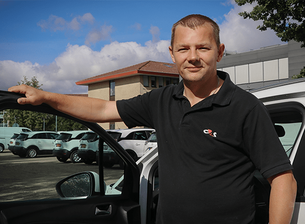 Hans foran G4S biler på parkeringsplads