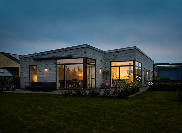 Hus set i mørke med lys i vinduerne