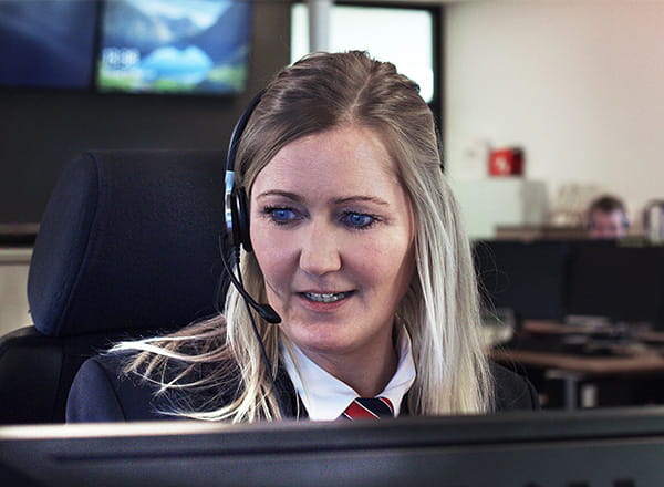 Kvindelig kontrolcentralmedarbejder der ser på sin skærm