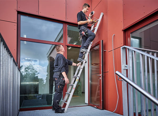 Montører på stigen foran bygning