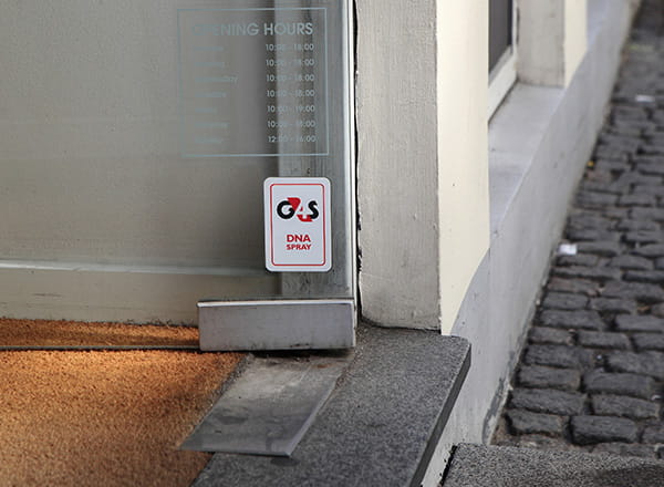 Skilt på butiksdør der advarer om DNA-spray