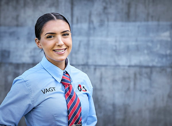 Kvindelig vagt foran grå væg