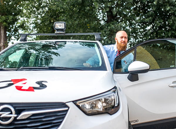 Vagt træder ud af G4S bil