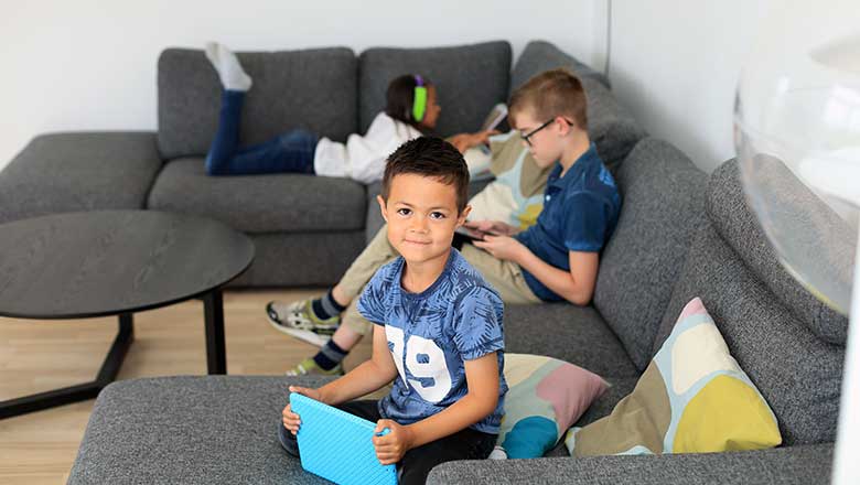 Børn sidder sammen i en sofa