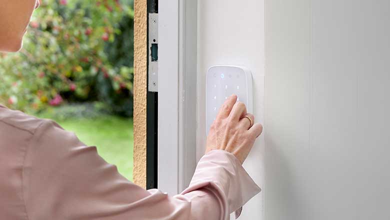 Kvinde betjener alarmens betjeningspanel