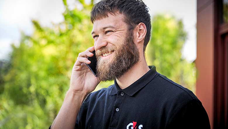 Montør smiler mens han taler med en kunde i sin mobil