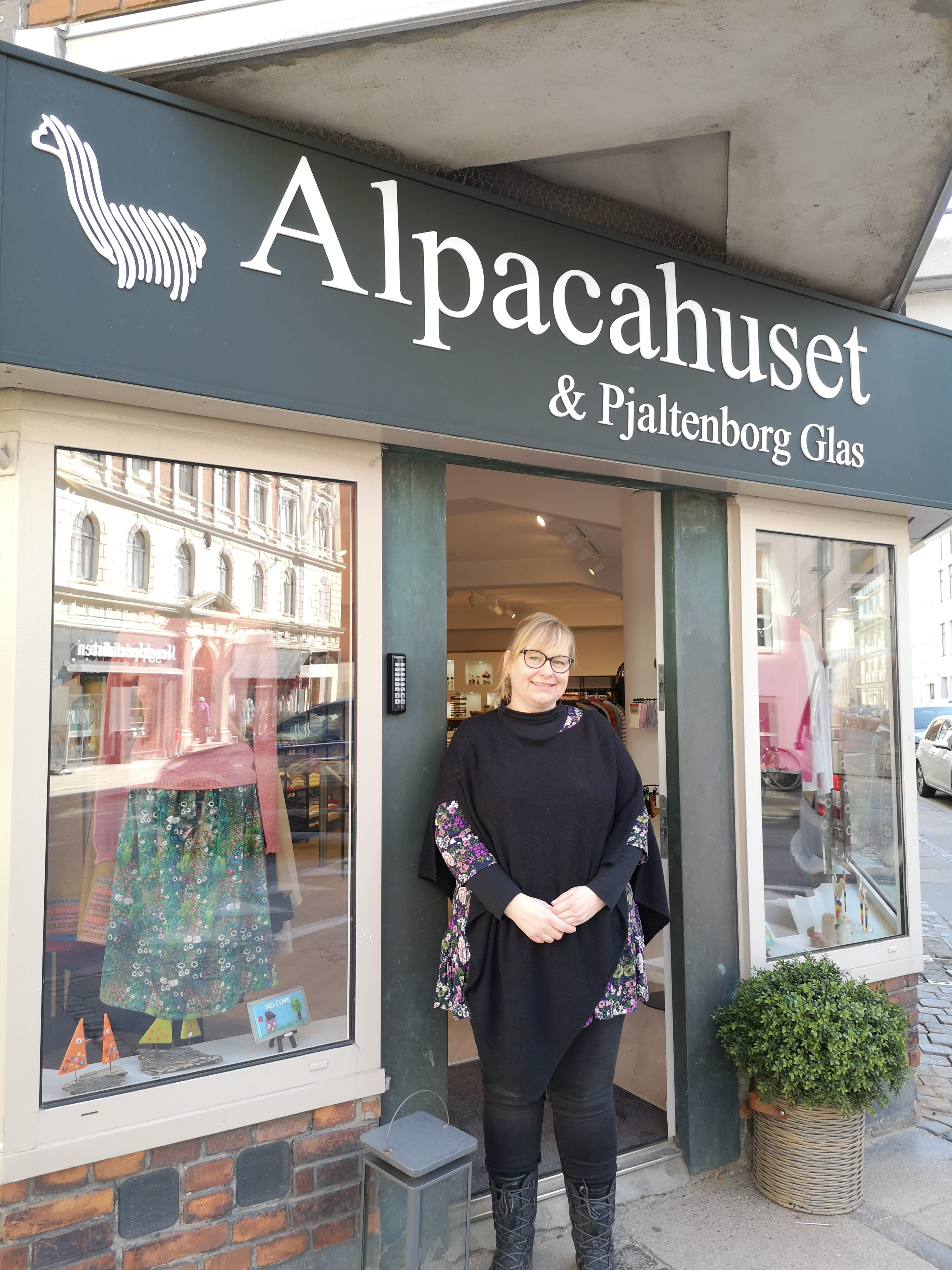 Billede af ejeren foran butikken