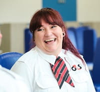 Women employee laughing wearing white shirt in corrections facility
