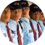 Thailand G4S males standing in a line wearing G4S light blue uniform