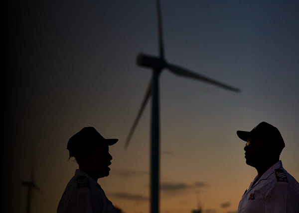 Two people in front of a windmill