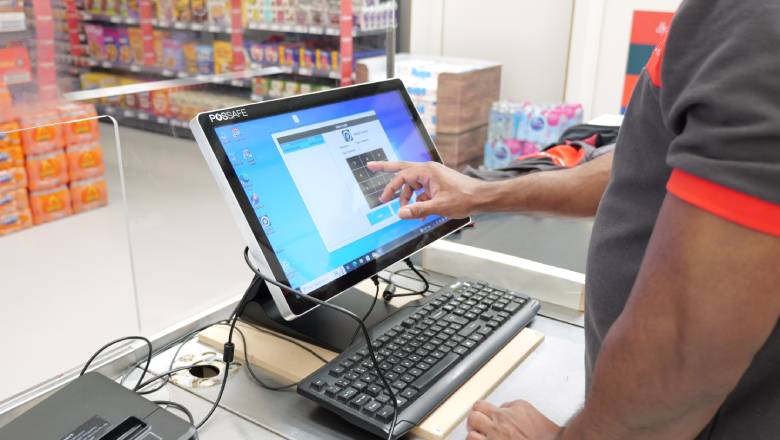 Person using touchscreen computer at checkout counter.