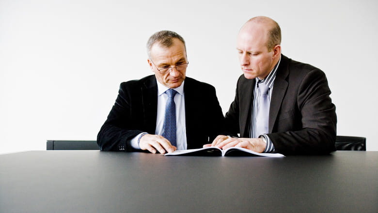 Two people looking at meeting papers