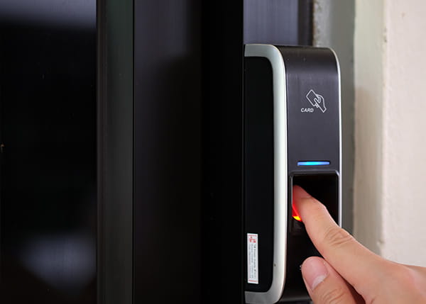 A fingerprint scanning machine on a black door