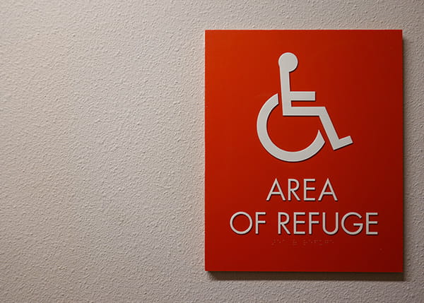 A red refuge area board hanging on a white wall