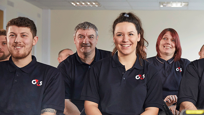 G4S employees smiling and sitting in a room