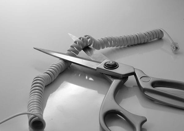 Scissors cutting a phone cord