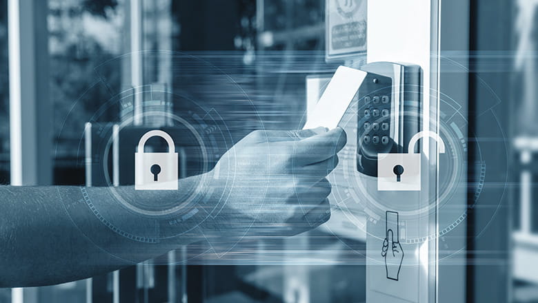 a hand holding a card scanning in front of a door for entrance