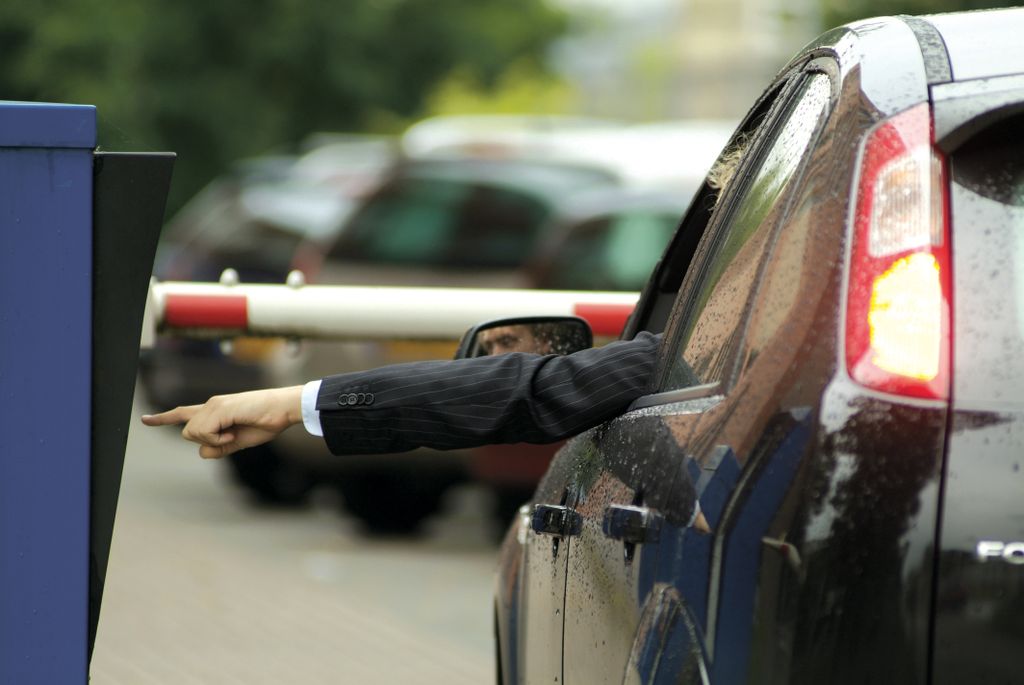 A car entering a car park with security gates