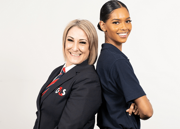 G4S women staff standing back-to-back smiling