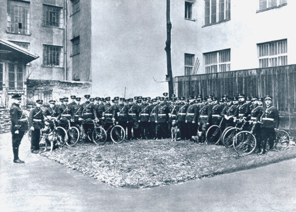 A group of guards with bikes and guarding dogs in 1930
