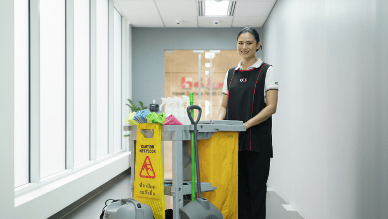 Facilities management services in Thailand: female cleaning professional with equipment in a modern indoor space.