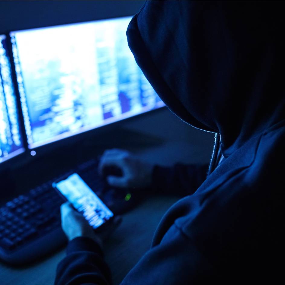 An insider retrieving confidential data on their phone and computer screen