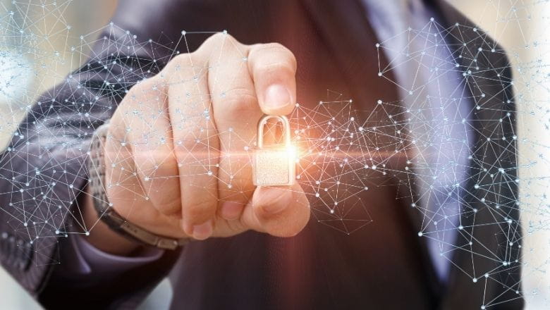 Roka turot zeltītu atslēgu simbolizējot datu aizsardzību. 