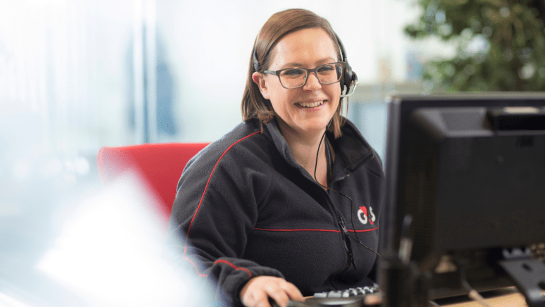 Sieviete G4S formas tērpā pie datora