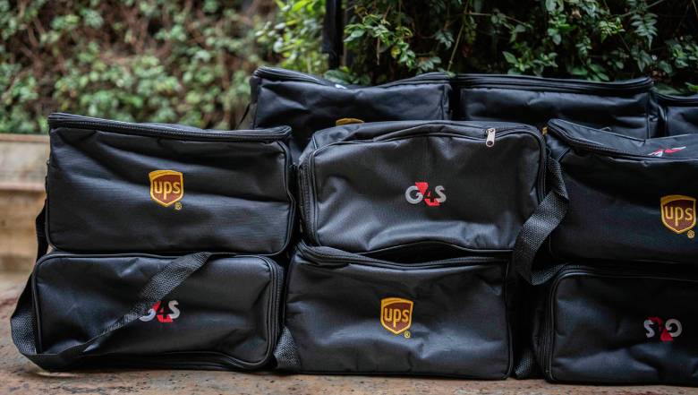 A stack of black G4S and UPS branded delivery bags