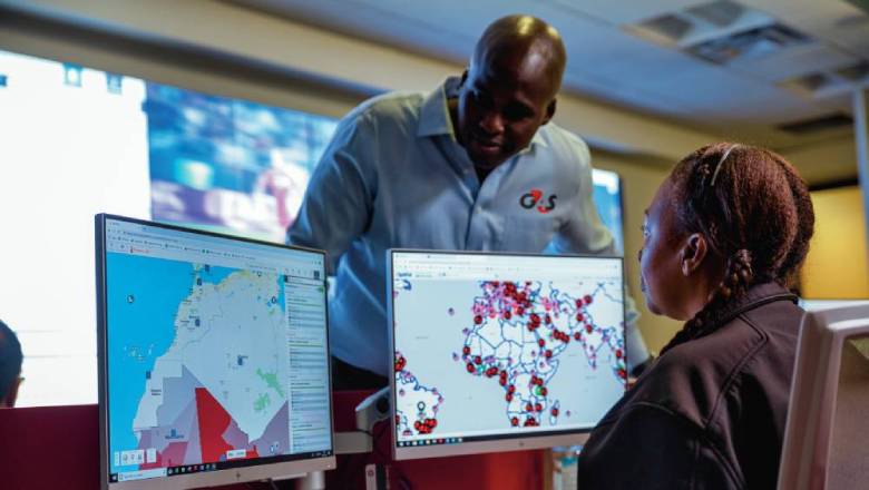 Two G4S security officers looking at 2 computer screens with data on them